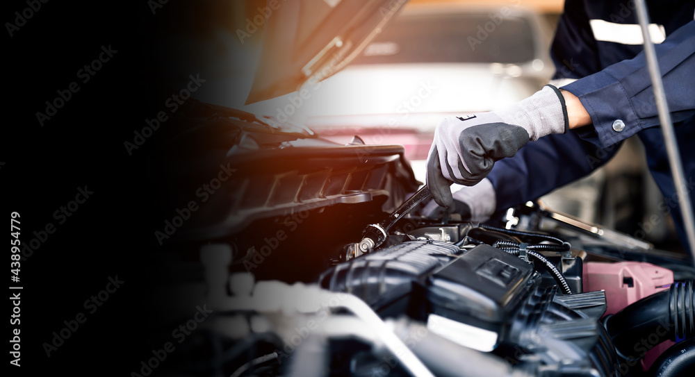 Professional mechanic working on the engine of the car in the garage. Car repair service. The concep