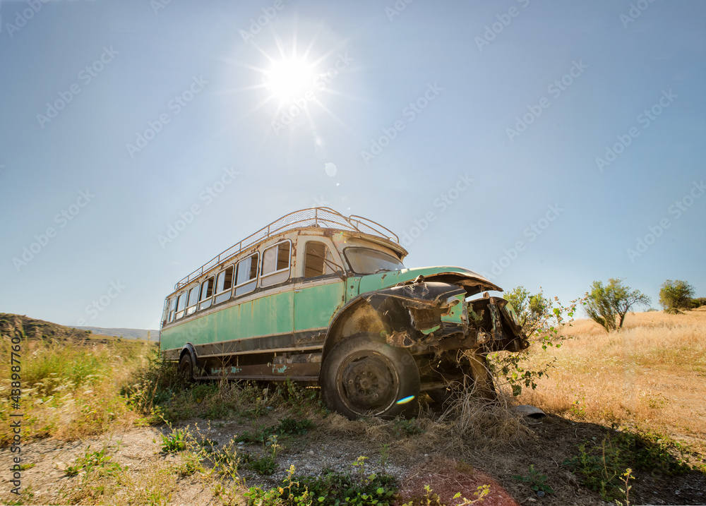 Abandoned Bedford village bus in rural landscape. Vintage transport backlit, lens flare