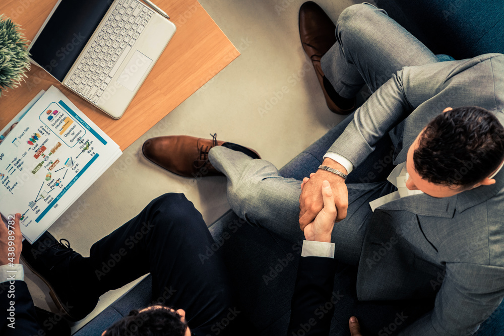 Businessman handshake with another businessman partner in modern workplace office. People corporate 