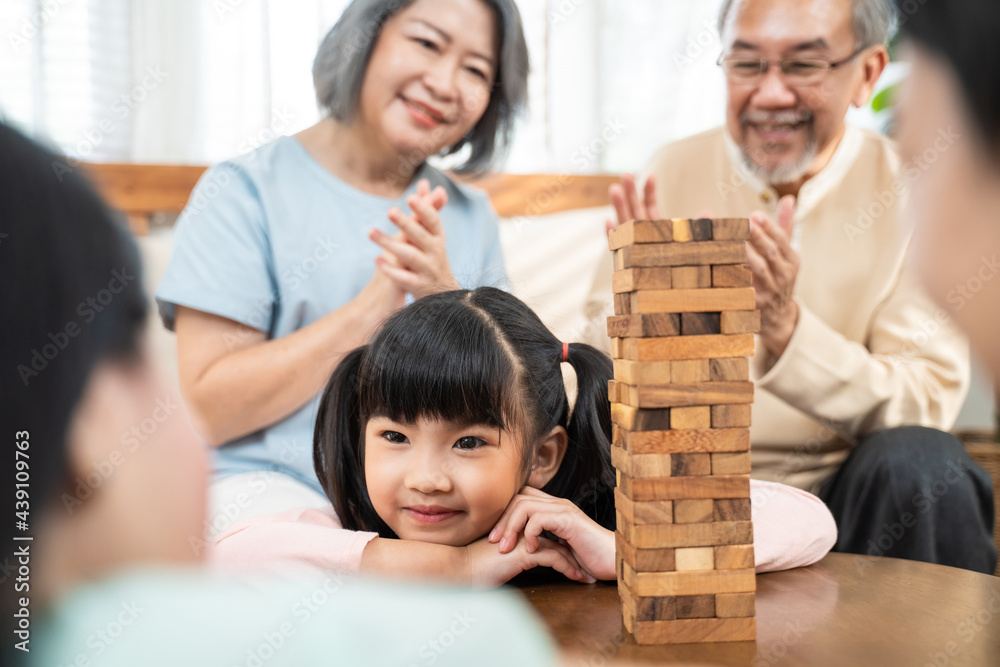 Portrait Little kid play toy block with family in living room at home.