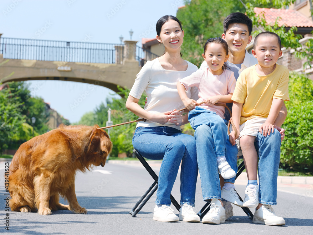 Happy family of four and pet dog in outdoor photo