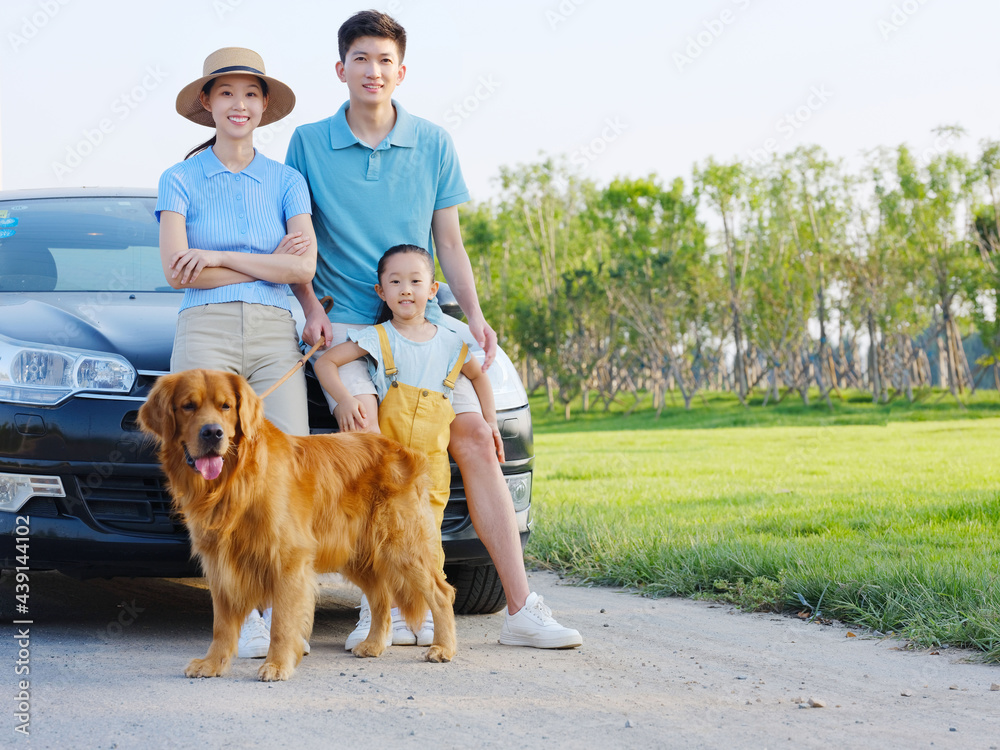 Happy family of three and pet dog in parking lot