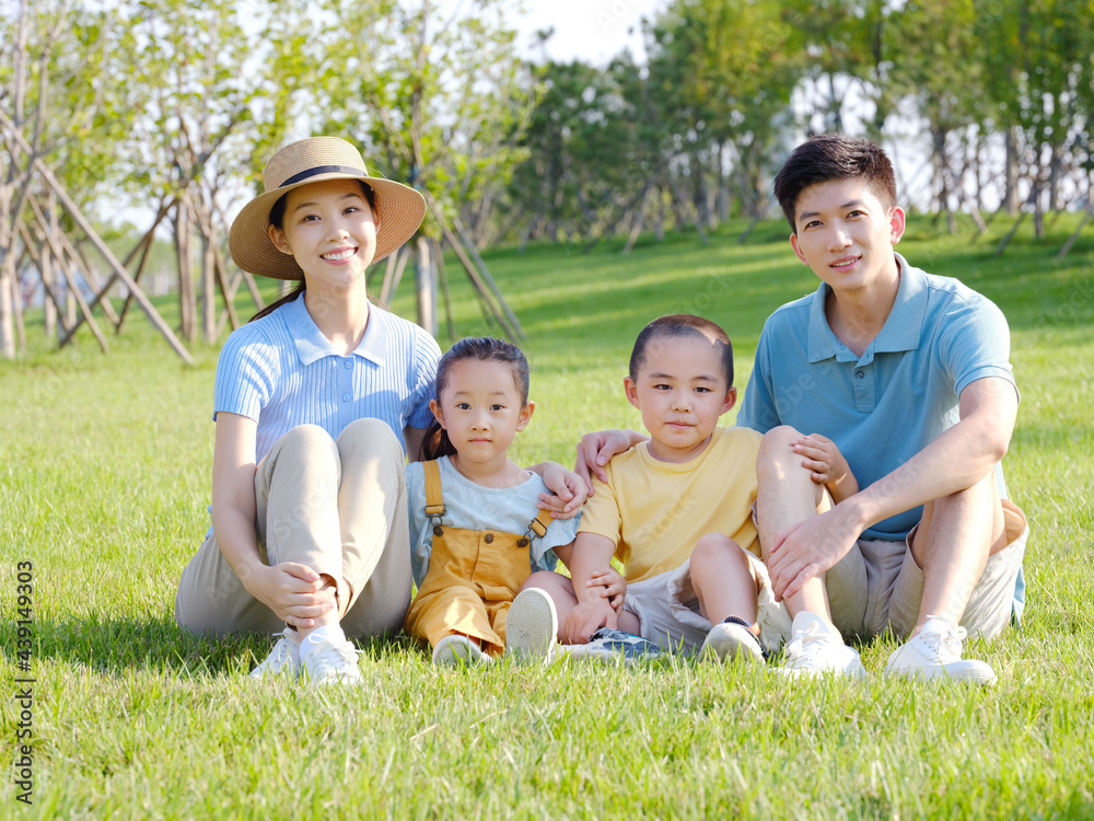 幸福的一家四口坐在草地上