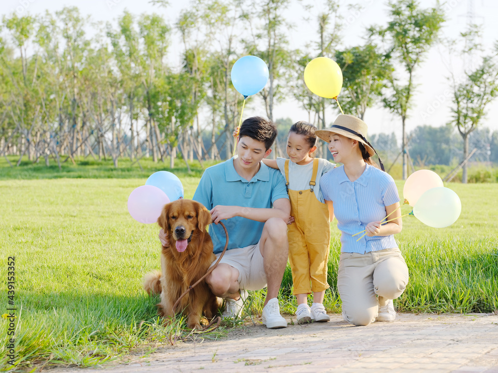 Happy family of three and pet dog in the park