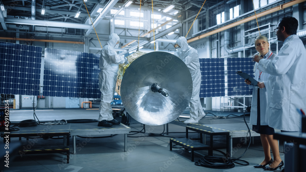 Engineer and Technician in Protective Suits Working on Satellite Construction. Aerospace Agency: Tea