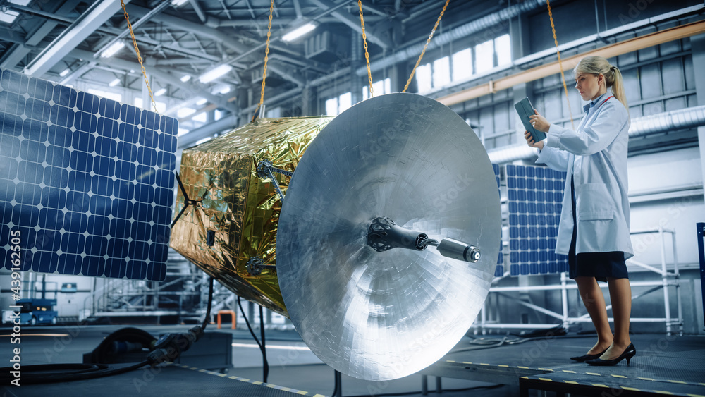 Female Engineer Uses Digital Tablet Computer while Working on Satellite Construction. Aerospace Agen