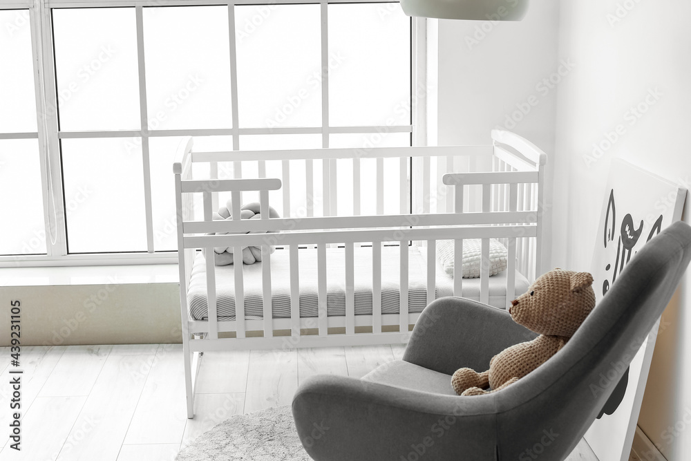 Interior of stylish childrens room with modern armchair and bed