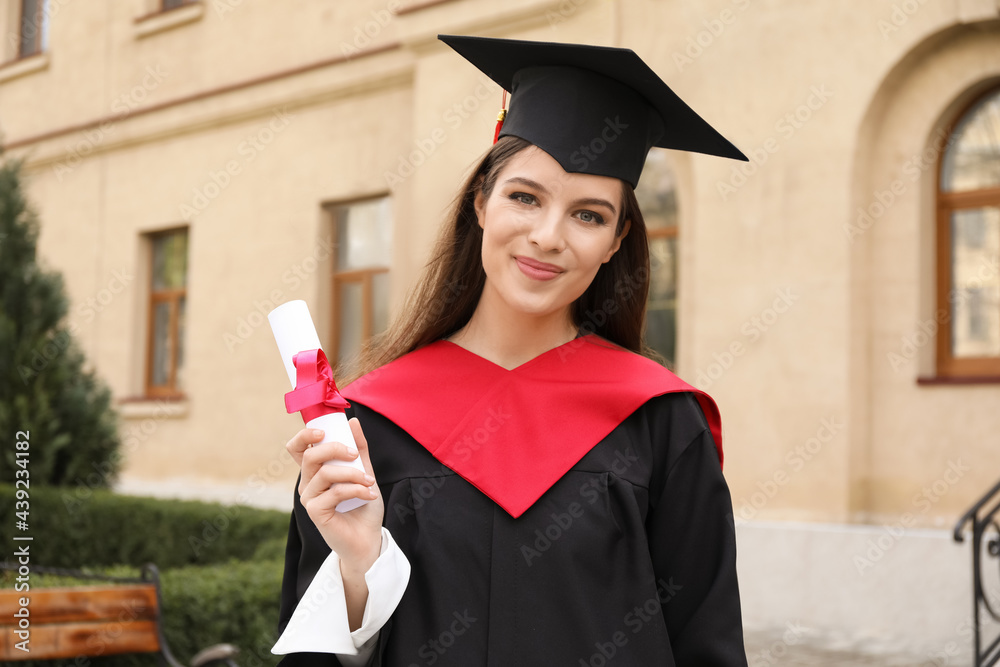 Female student in bachelor robe and with diploma on her graduation day