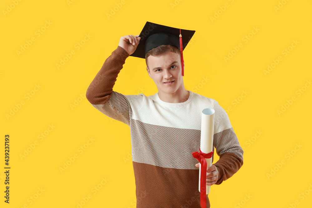 Male graduating student on color background