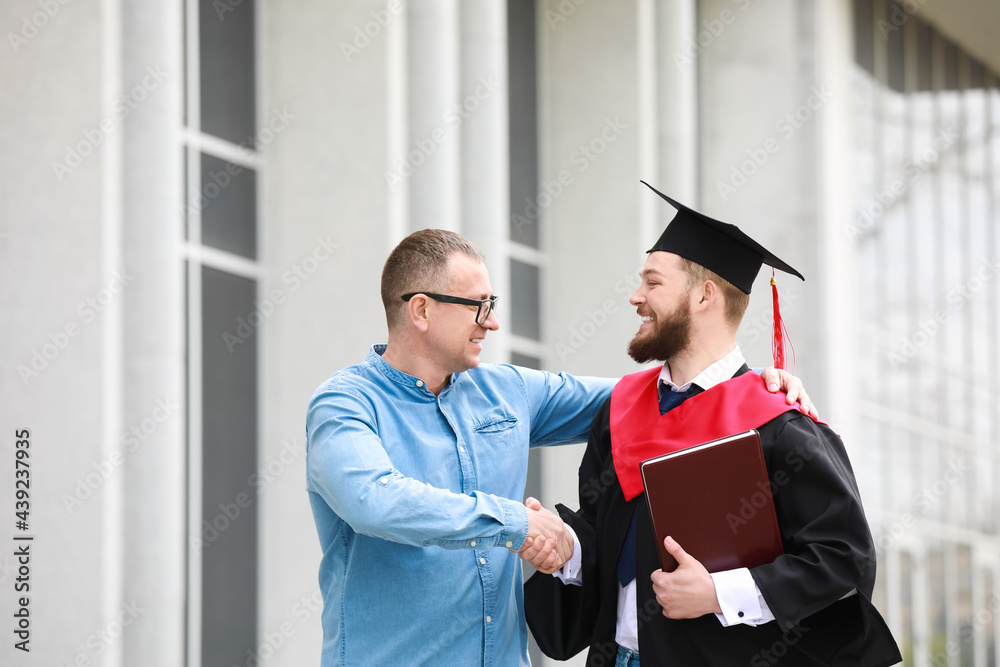 Happy young man with his father on graduation day