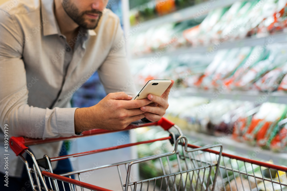 Man playing with his phone at supermarket