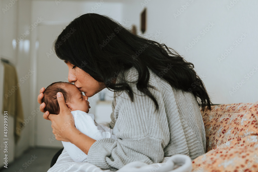 Loving mother kissing her infant baby