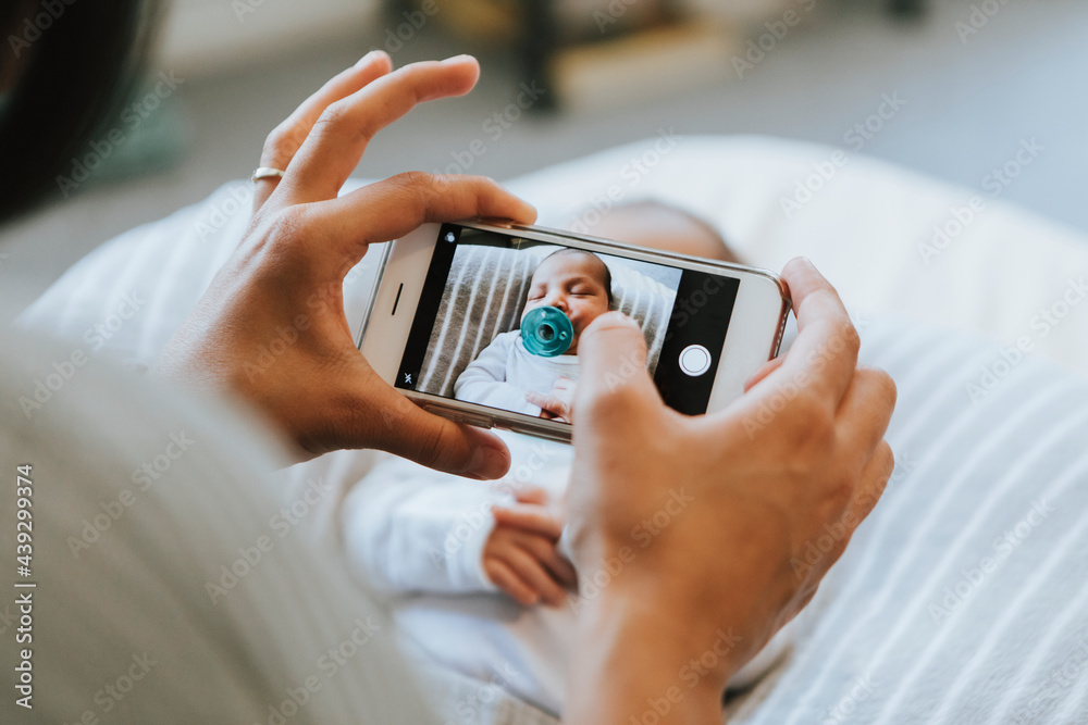 Mother snapping a photo of her newborn