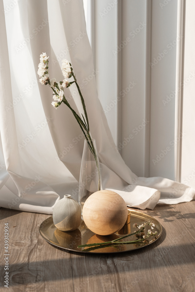 White statice flower in a clear vase on a wooden floor