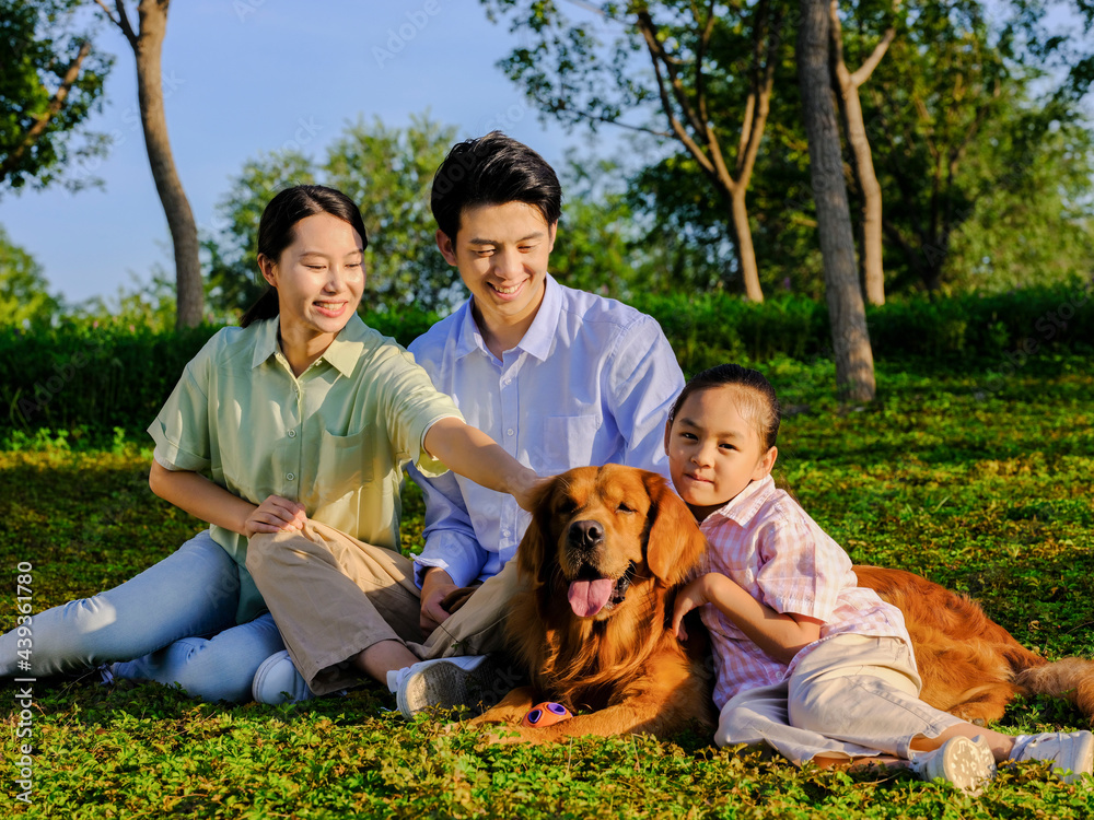 幸福的三口之家和公园里的宠物狗