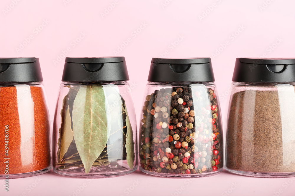 Jars with different spices on color background, closeup