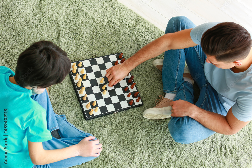 Father and son playing chess at home