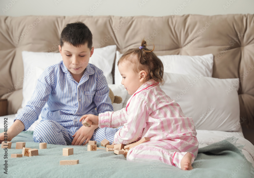 Cute little children playing with toys in bedroom