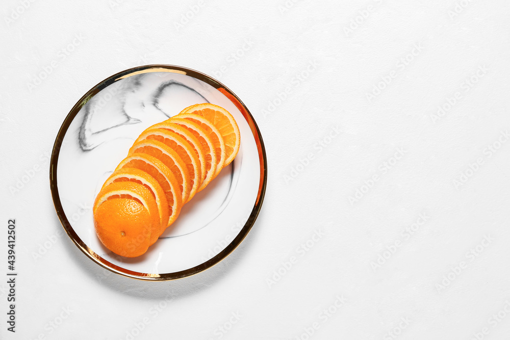 Plate with sliced juicy orange on light background