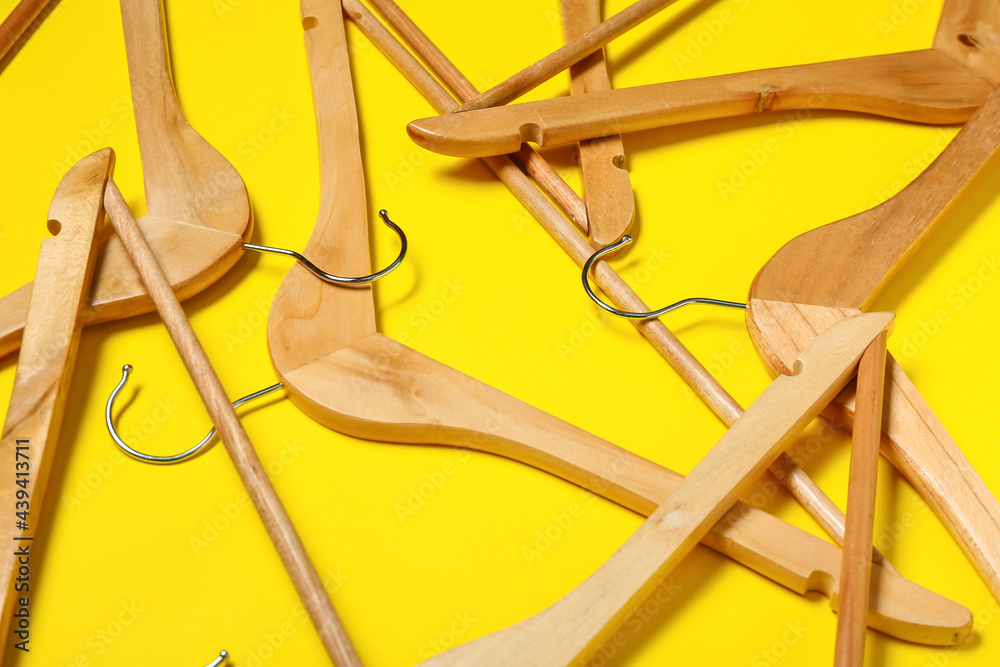 Stylish clothes hangers on color background, closeup