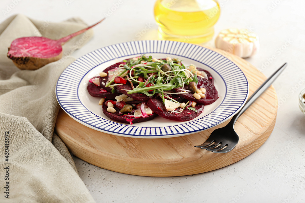 Plate with delicious beetroot carpaccio on light background