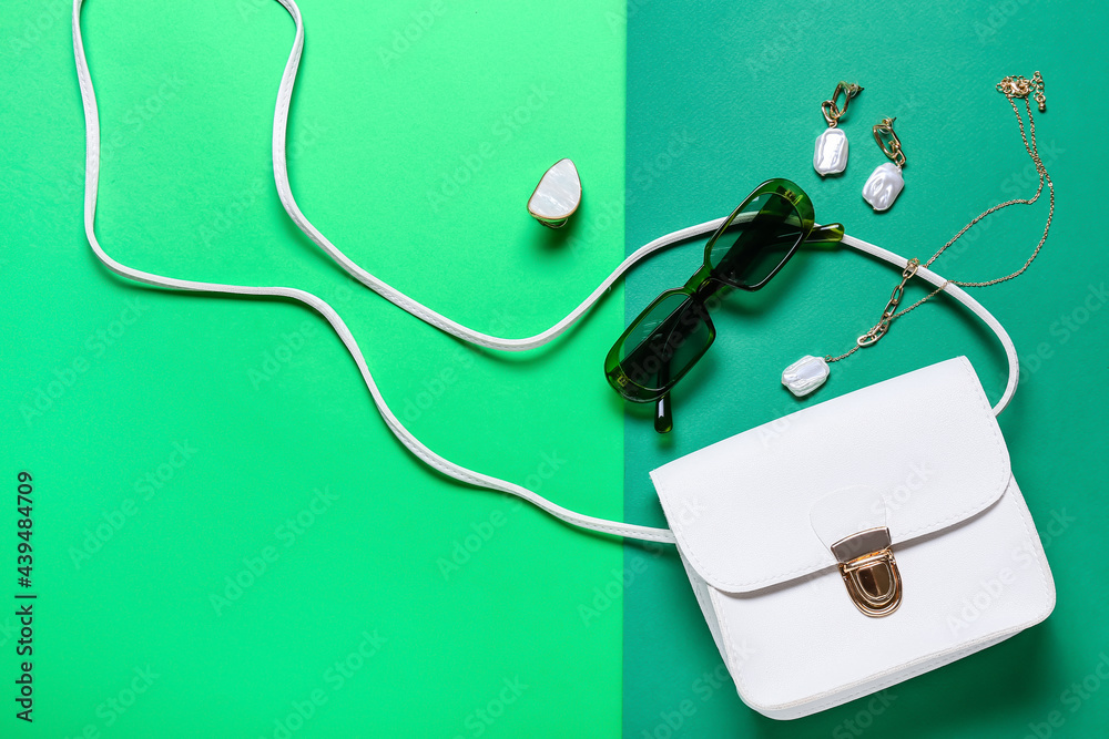 Stylish female accessories on color background