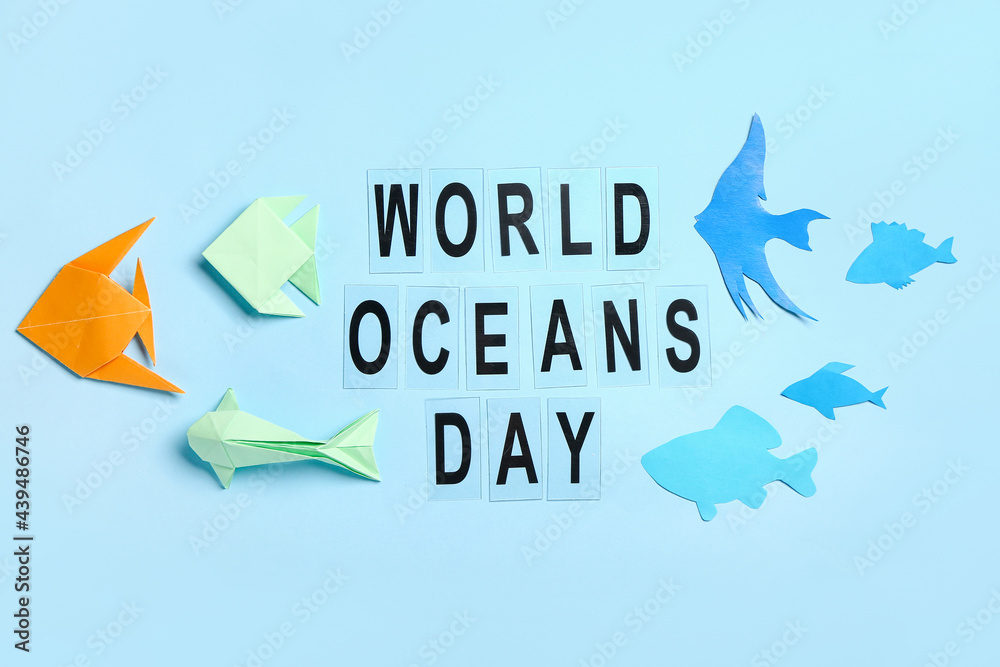 Text WORLD OCEAN DAY and paper fishes on color background