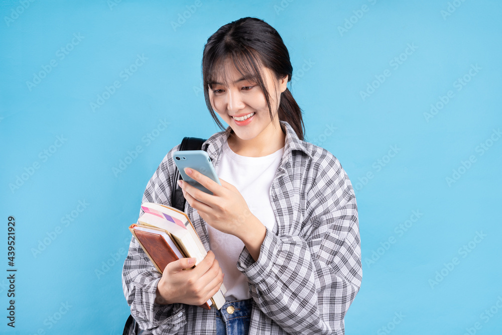 Asian female student with playful expression on blue background