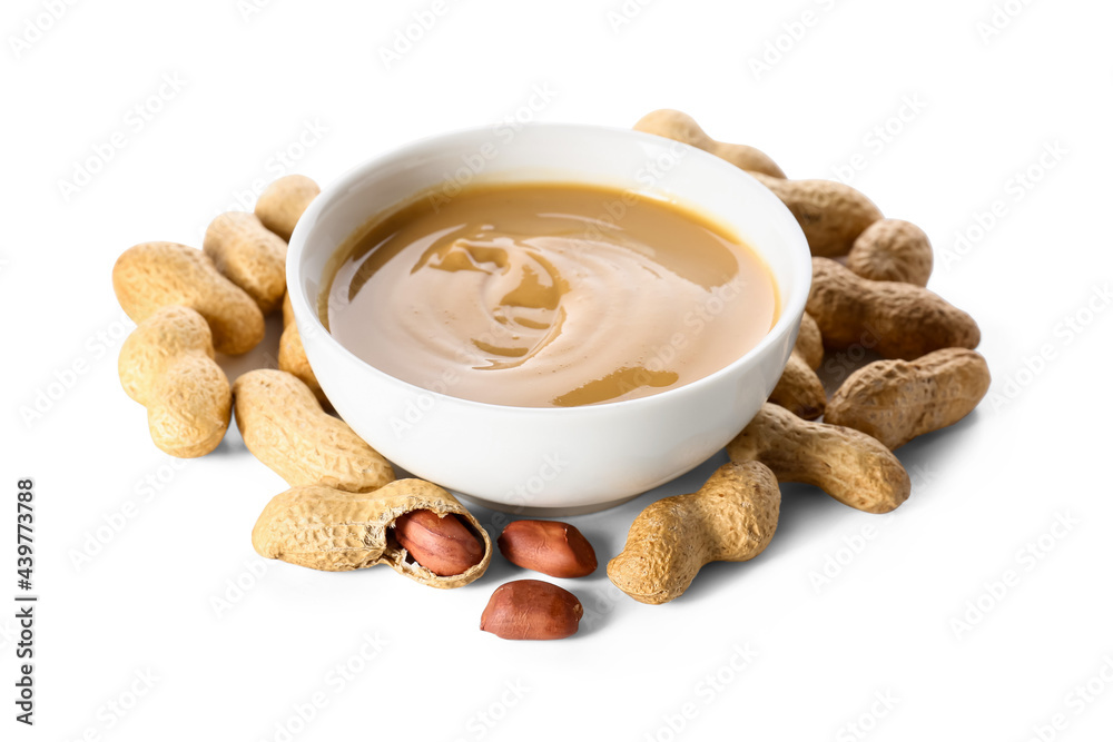 Bowl with tasty peanut butter on white background