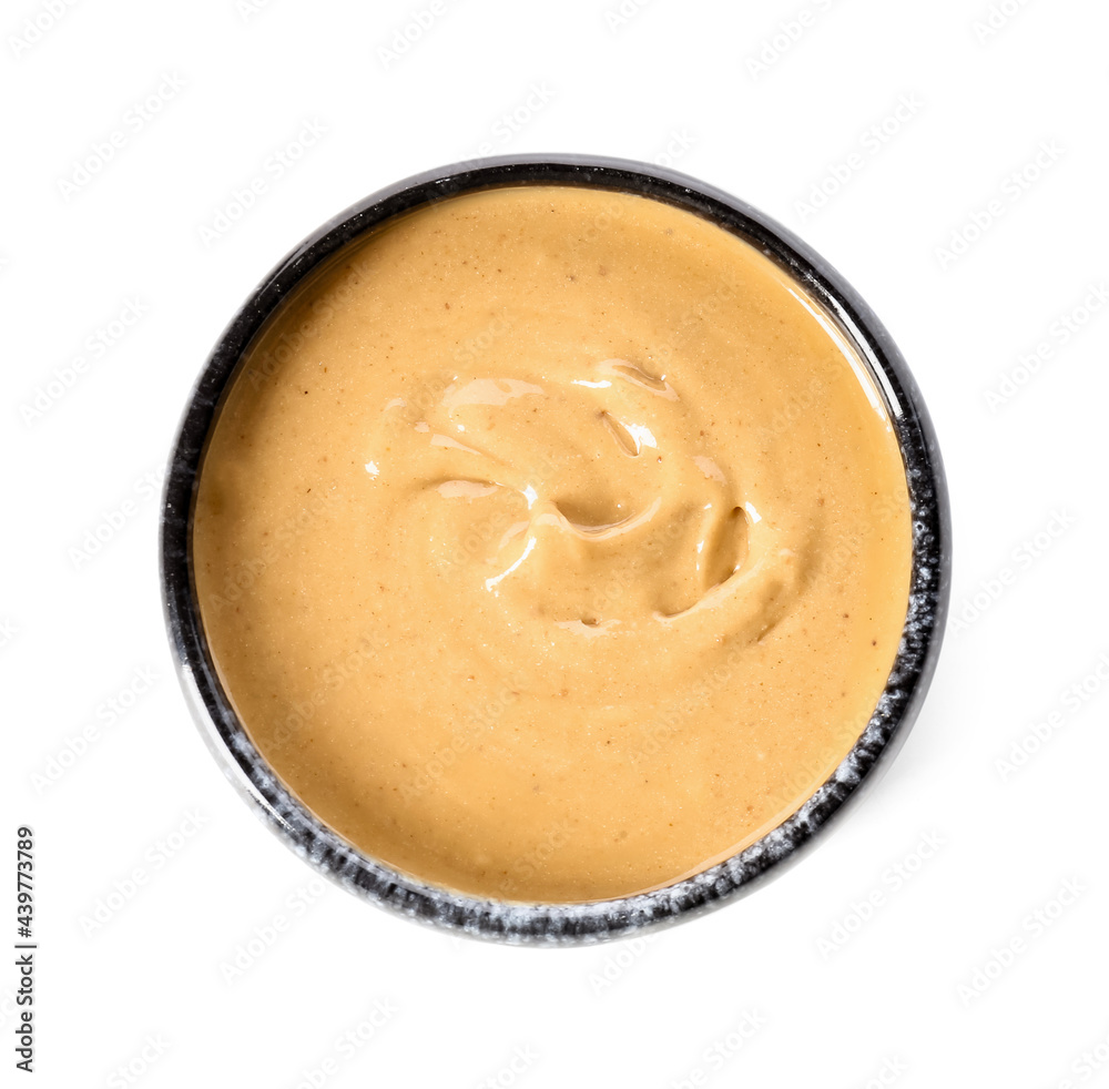 Bowl with tasty peanut butter on white background