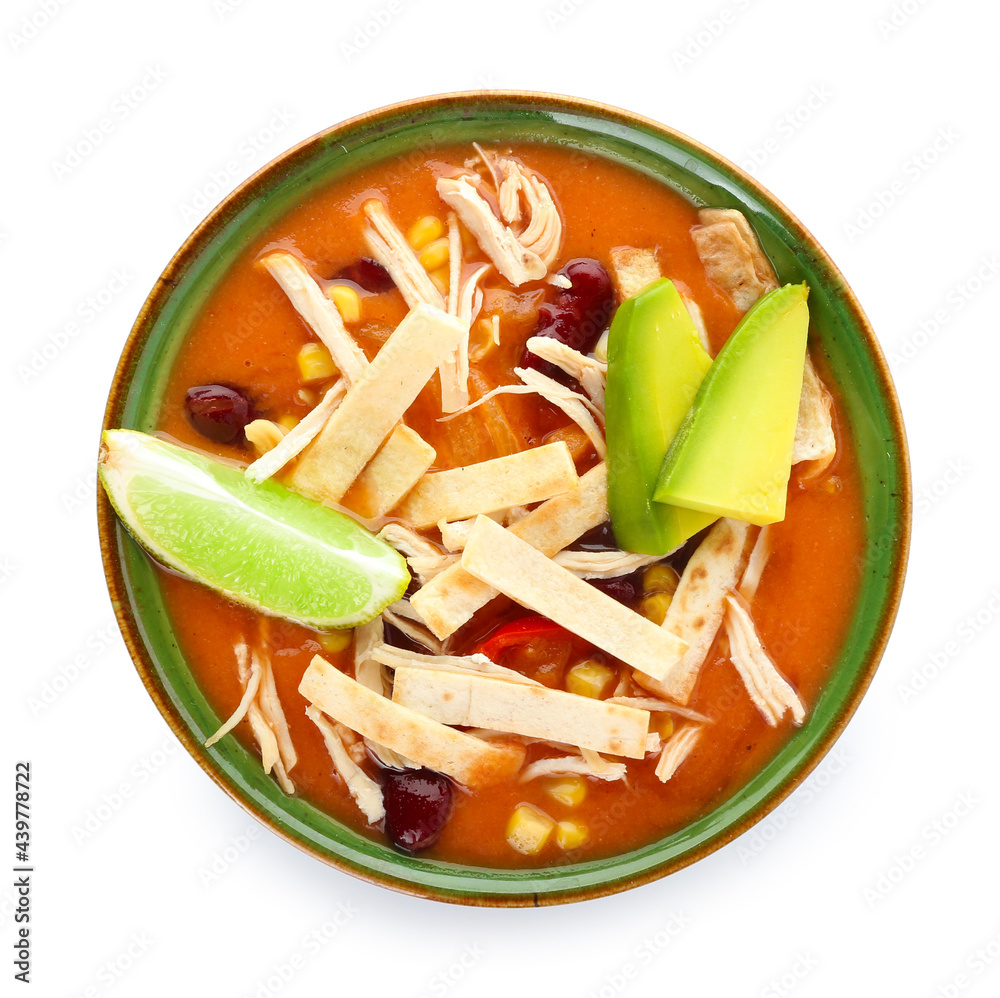 Bowl of tasty chicken enchilada soup on white background