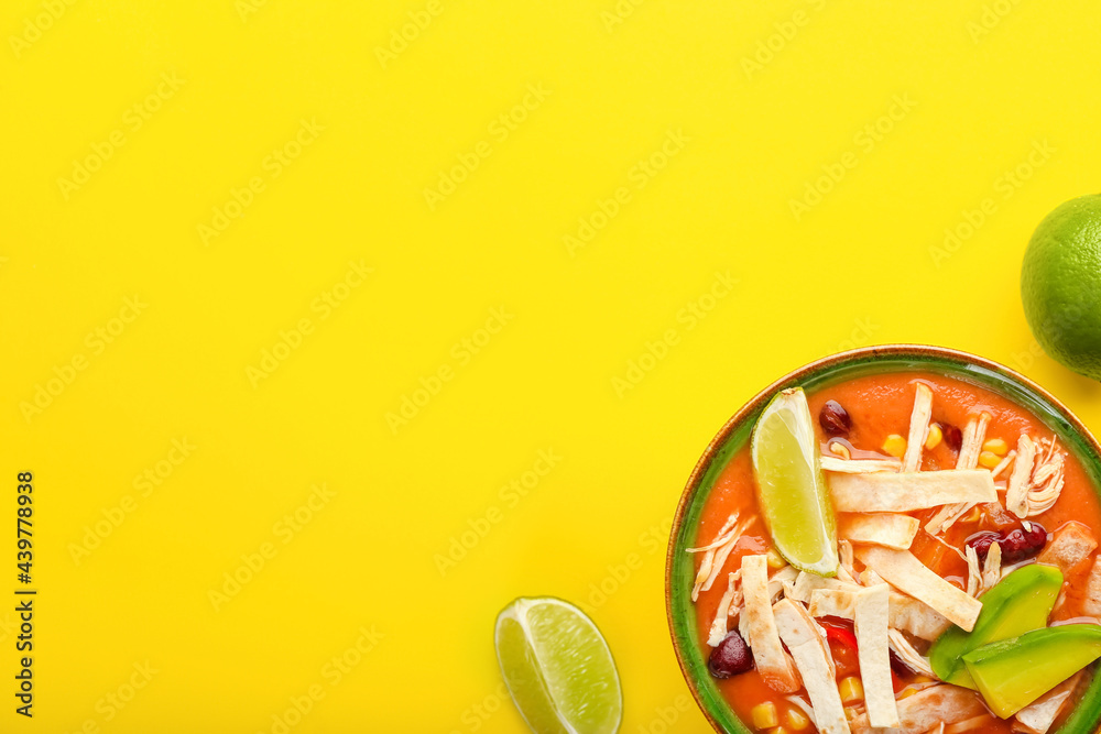 Bowl of tasty chicken enchilada soup on color background