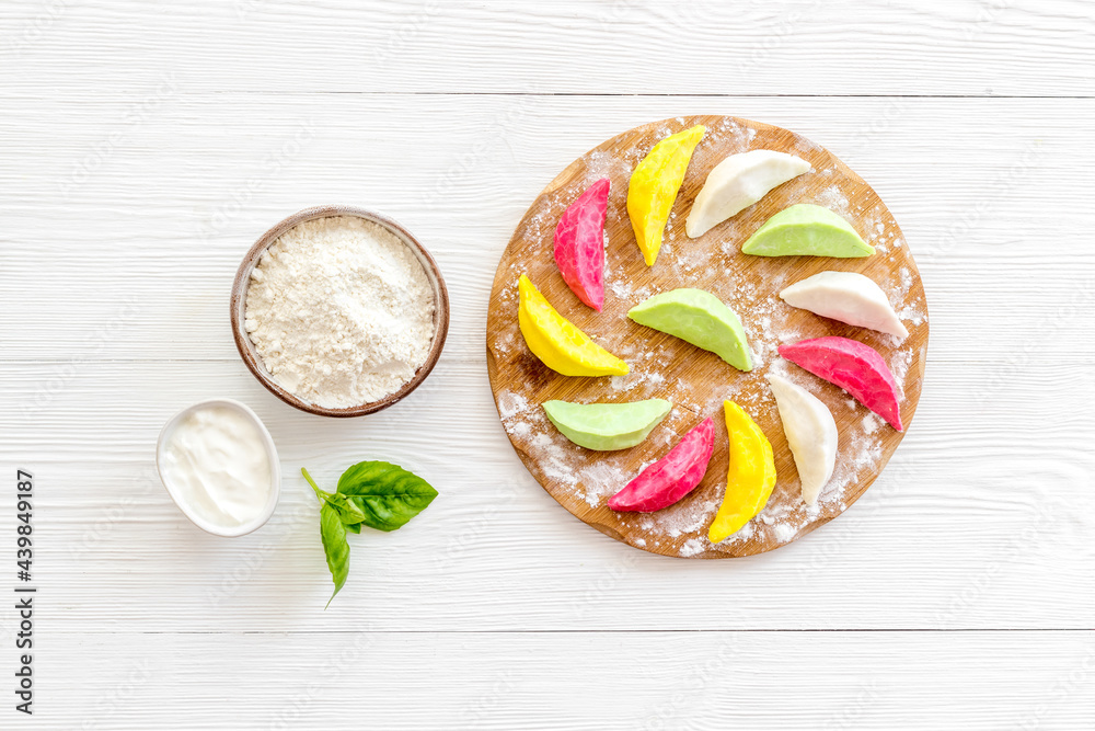 Chinese colorful raw dumplings or ravioli on cutting board, top view