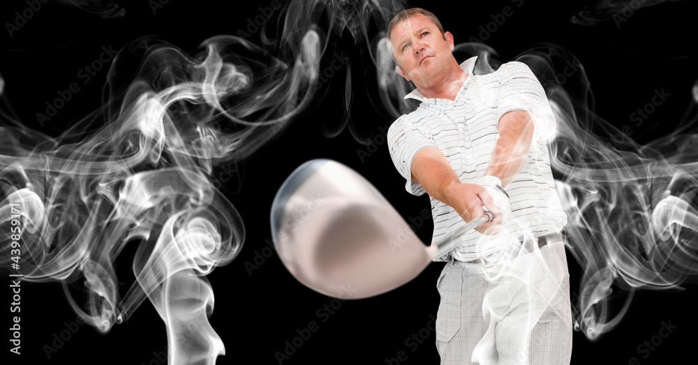 Caucasian male golf player swinging golf club against smoke effect on black background