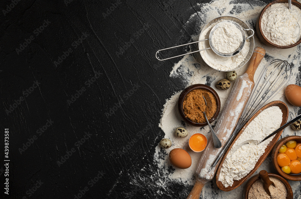 Baking ingredients for dough on black background