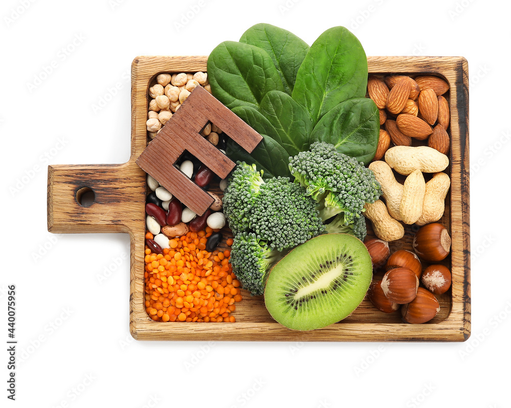 Board with healthy products rich in vitamin E on white background