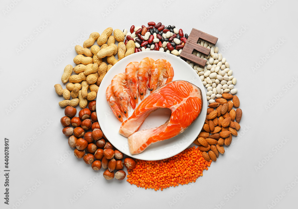 Plate with healthy products rich in vitamin E on white background