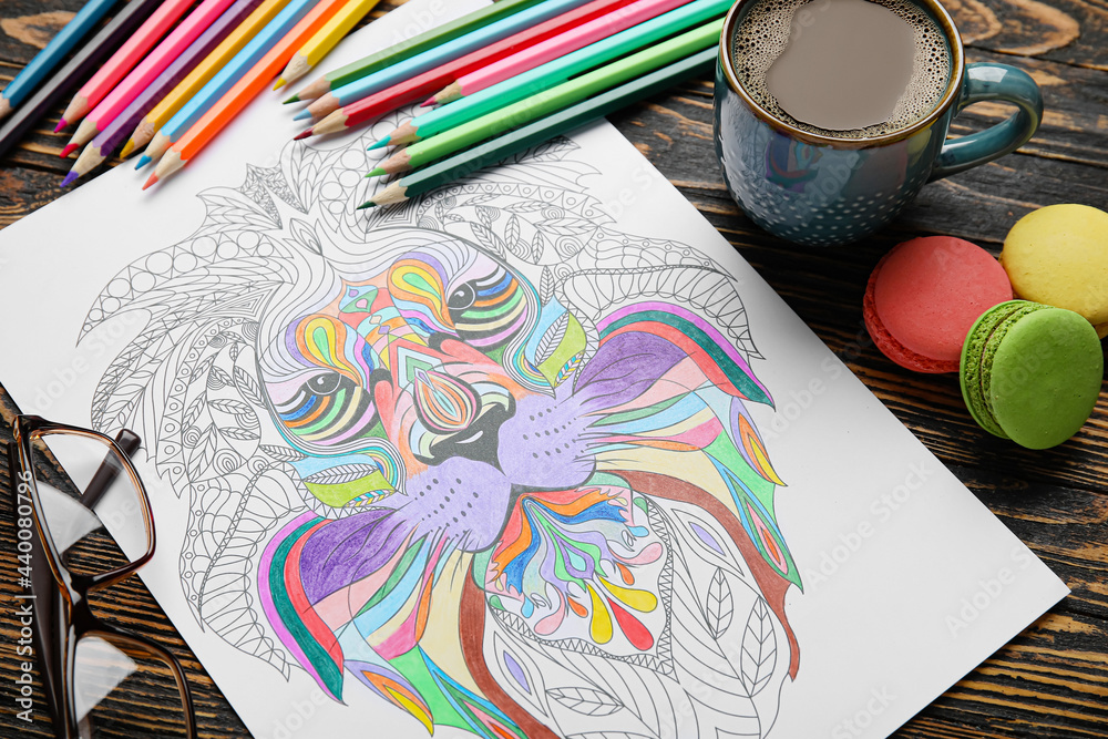 Coloring picture, pencils, glasses and cup of coffee on wooden background