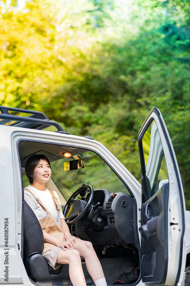 車の運転席に座る若い女性