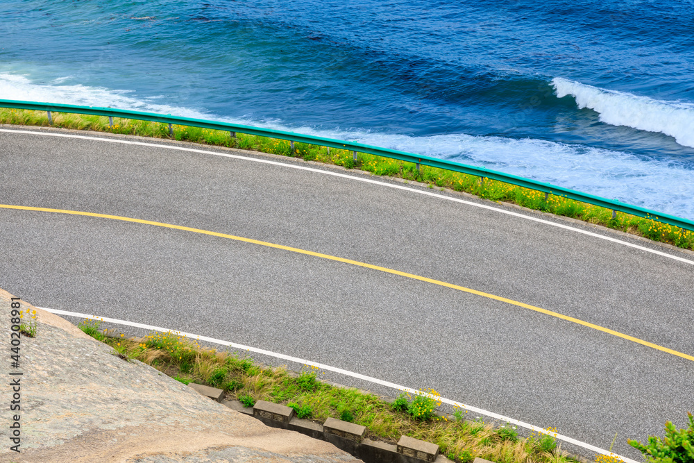 沥青公路和蓝海自然景观。高角度视角。