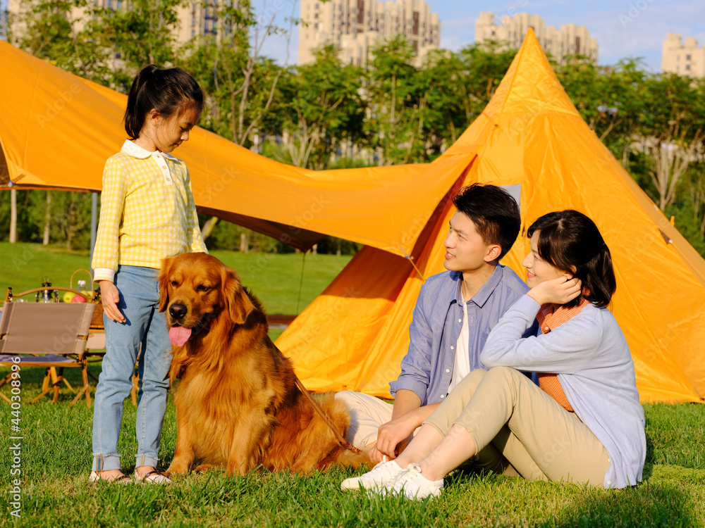 Happy family of three and pet dog in the park