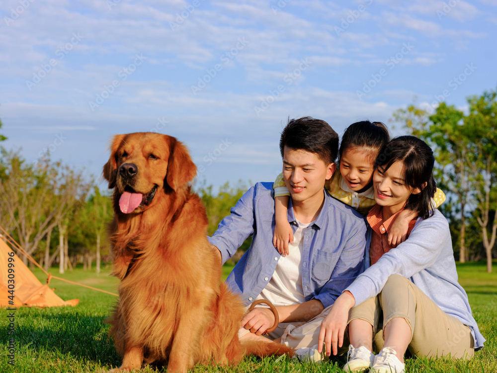 Happy family of three and pet dog in the park