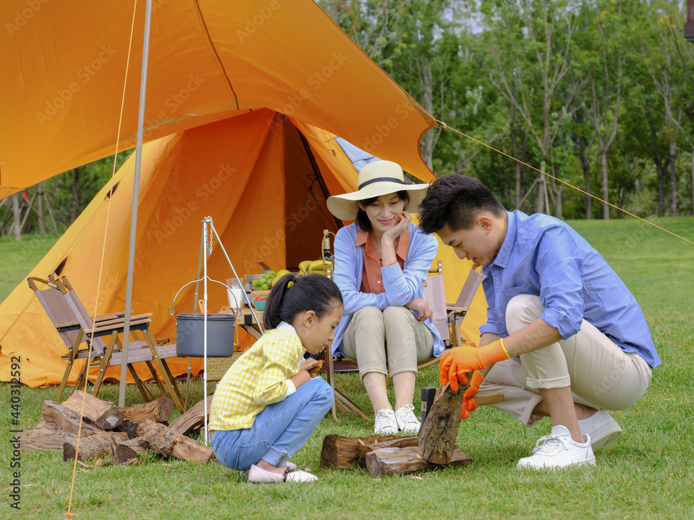 A Happy family of three camping outdoors