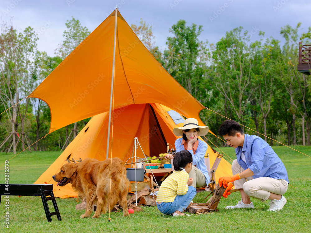 Happy family of three and dog camping out