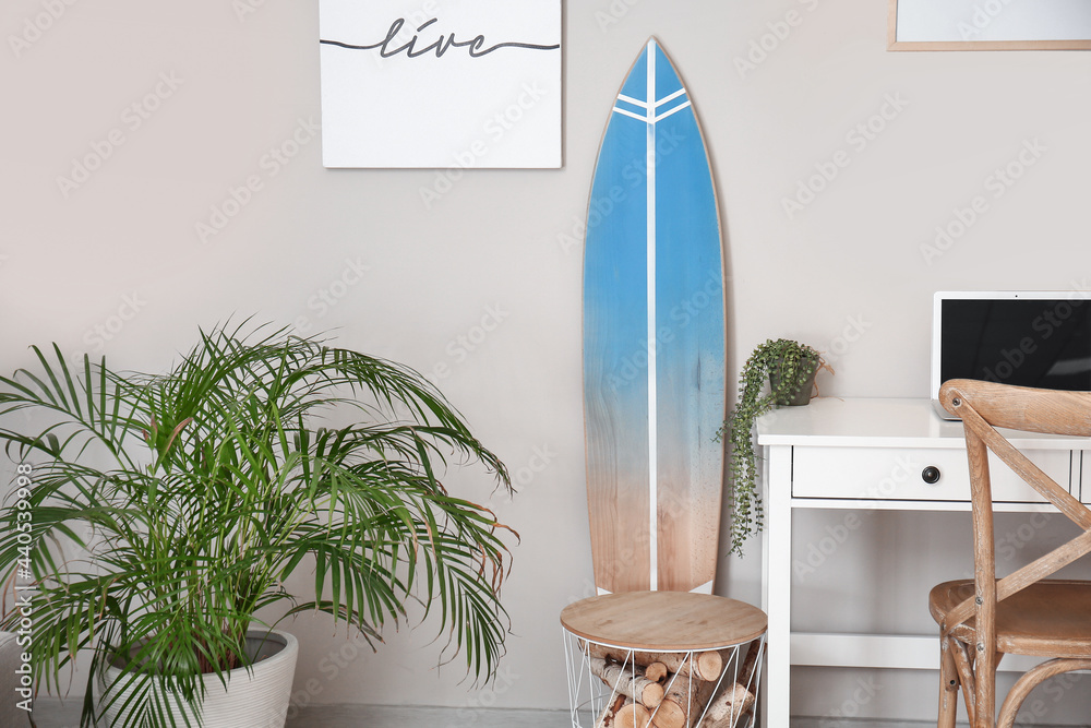 Interior of modern stylish room with surfboard and table with houseplants