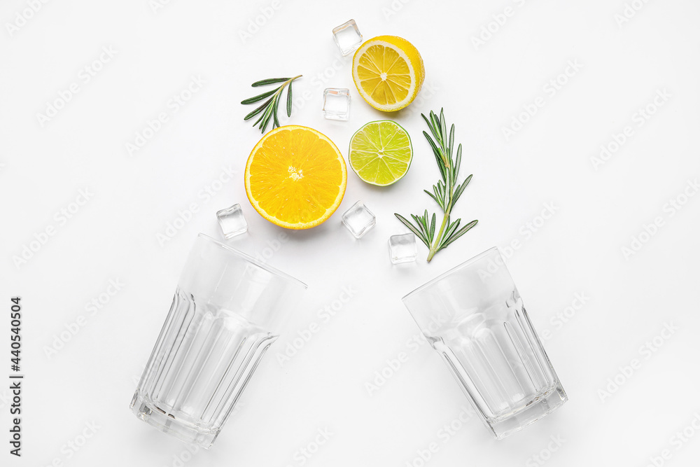 Composition with glasses and healthy citrus fruits on white background