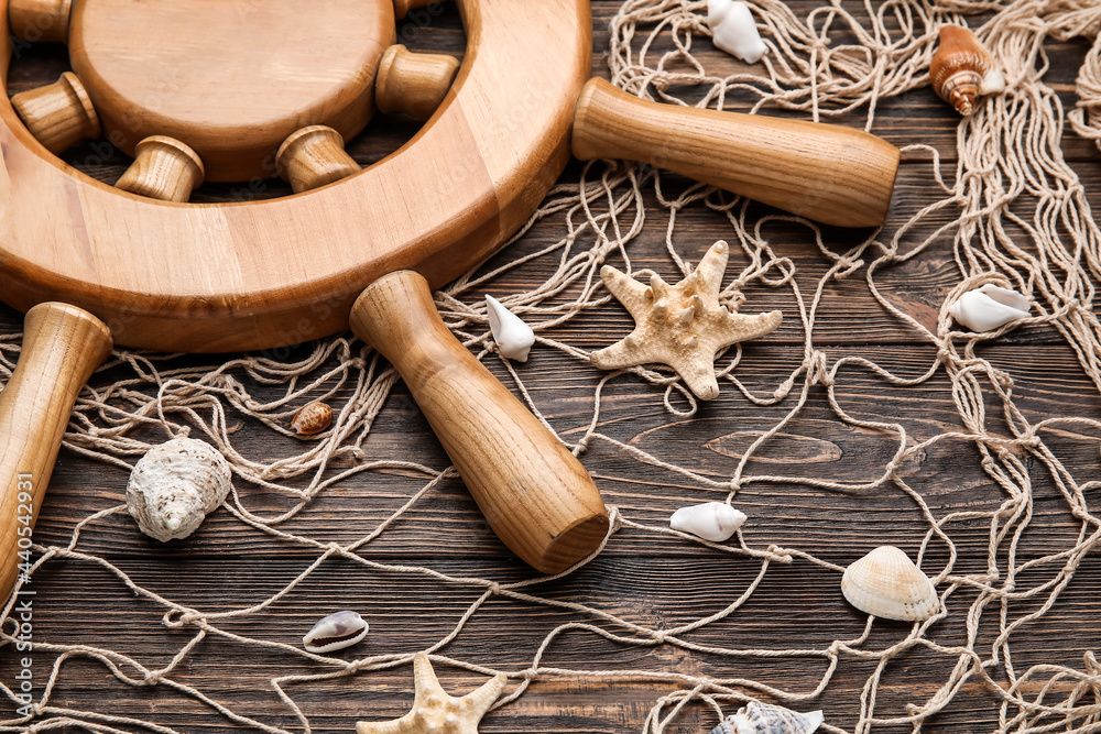 Helm, net and sea shells on wooden background