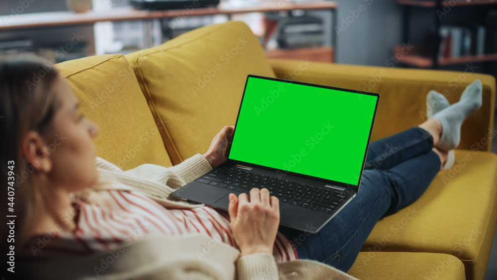 Beautiful Caucasian Specialist Working on Laptop with Green Screen Mock Up Display at Home Living Ro