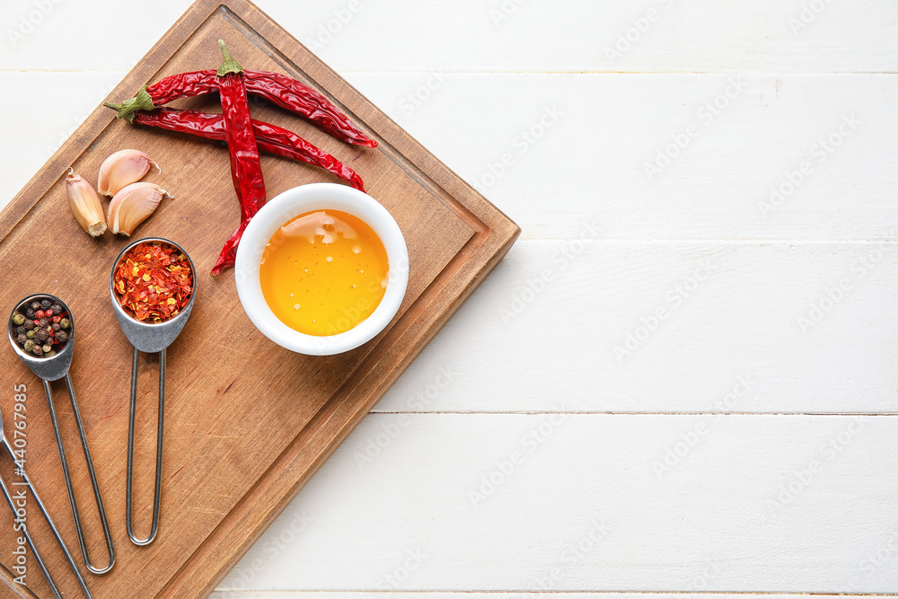 Board with honey and spices on light wooden background