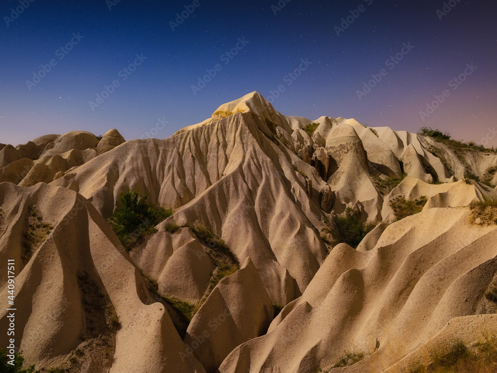 岩石和星星的天空。晚上可以看到岩石。夏天的风景。自然背景